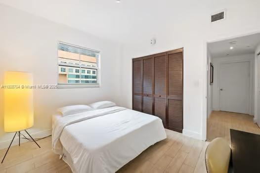185 SE 14th Ter Unit 1410, Miami, FL 33131 - bedroom with a closet, light wood-style flooring, and baseboards