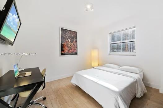 185 SE 14th Ter Unit 1410, Miami, FL 33131 - bedroom featuring light wood-type flooring, a desk, and baseboards