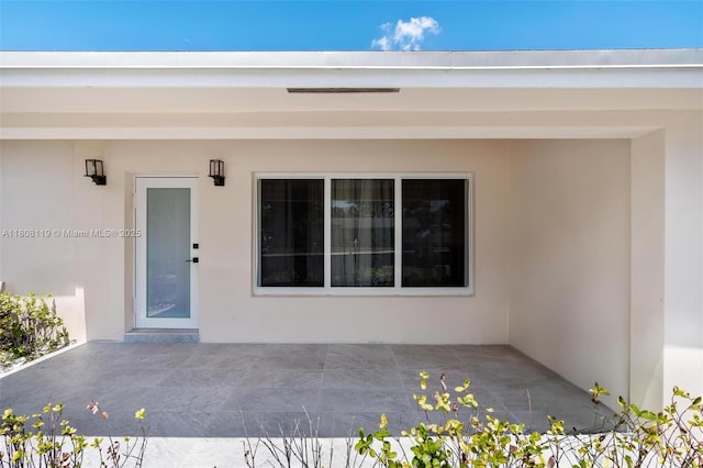 3201 NE 9th Ter, Pompano Beach, FL 33064 - doorway to property featuring stucco siding and a patio area