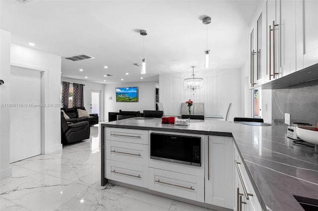 3201 NE 9th Ter, Pompano Beach, FL 33064 - kitchen featuring black microwave, a peninsula, white cabinetry, light marble finish flooring, and open floor plan