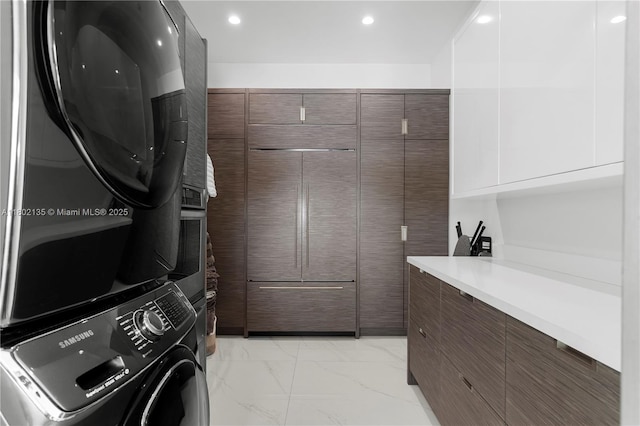 12880 N Bayshore Dr, North Miami, FL 33181 - laundry room featuring stacked washer / drying machine, light marble finish floors, and recessed lighting