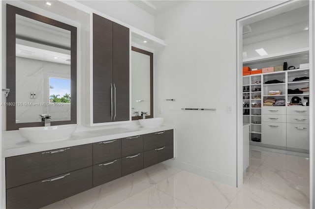 12880 N Bayshore Dr, North Miami, FL 33181 - bathroom featuring double vanity, a spacious closet, marble finish floors, and baseboards