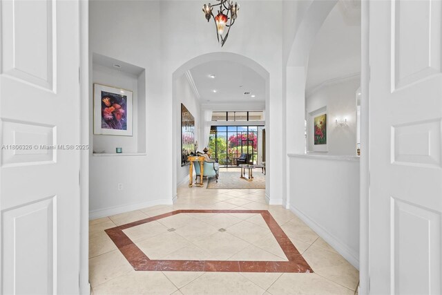 11034 Via, San Remo, Boynton Beach, FL 33437 - tiled foyer entrance featuring arched walkways, baseboards, crown molding, recessed lighting, and inlaid floor details