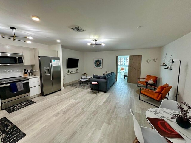 19380 NE 26th Ave Unit 301, Miami, FL 33180 - living area featuring light wood-style floors and a chandelier