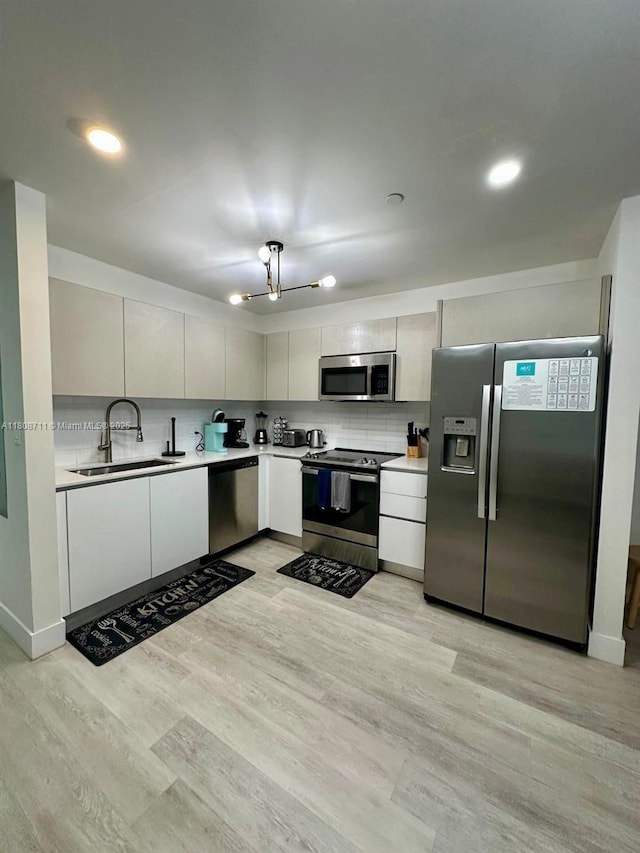 19380 NE 26th Ave Unit 301, Miami, FL 33180 - kitchen featuring stainless steel appliances, a sink, light countertops, and decorative backsplash