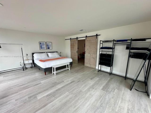 19380 NE 26th Ave Unit 301, Miami, FL 33180 - bedroom featuring wood finished floors, a barn door, and baseboard heating