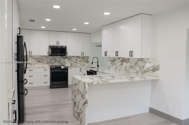 861 N Rainbow Dr, Hollywood, FL 33021 - kitchen featuring electric stove, stainless steel microwave, a peninsula, light stone countertops, and a sink