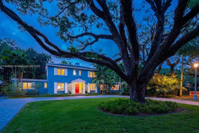 3245 Riviera Dr, Coral Gables, FL 33134 - view of front of house with curved driveway, a front lawn, and stucco siding