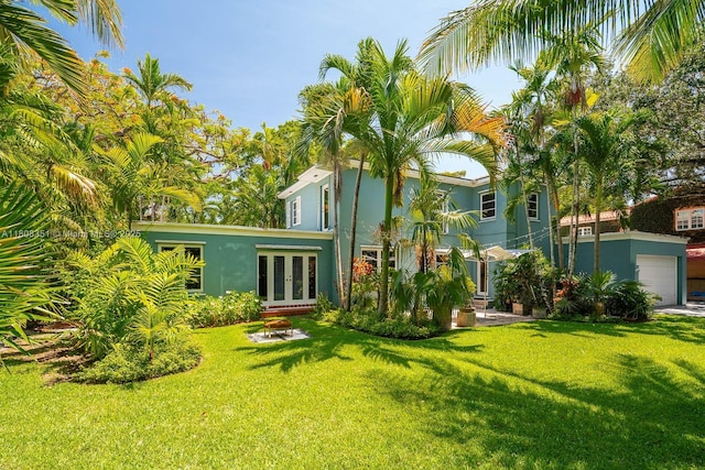 3245 Riviera Dr, Coral Gables, FL 33134 - rear view of house featuring french doors, a lawn, and stucco siding
