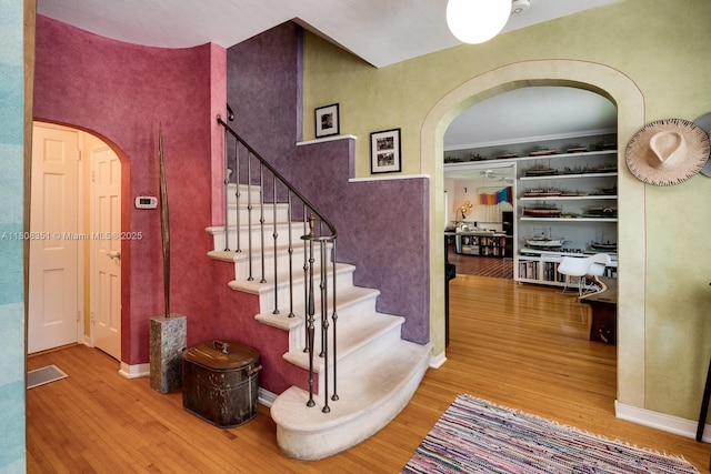 3245 Riviera Dr, Coral Gables, FL 33134 - stairway featuring arched walkways and wood finished floors
