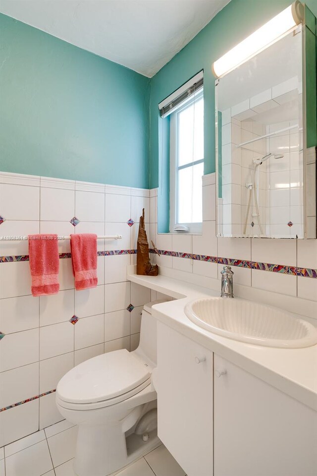 3245 Riviera Dr, Coral Gables, FL 33134 - full bath with toilet, a shower stall, tile walls, vanity, and tile patterned flooring