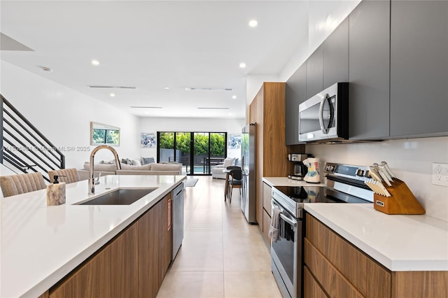 1116 NE 10th Ave, Fort Lauderdale, FL 33304 - kitchen featuring appliances with stainless steel finishes, a sink, modern cabinets, light tile patterned flooring, and light countertops