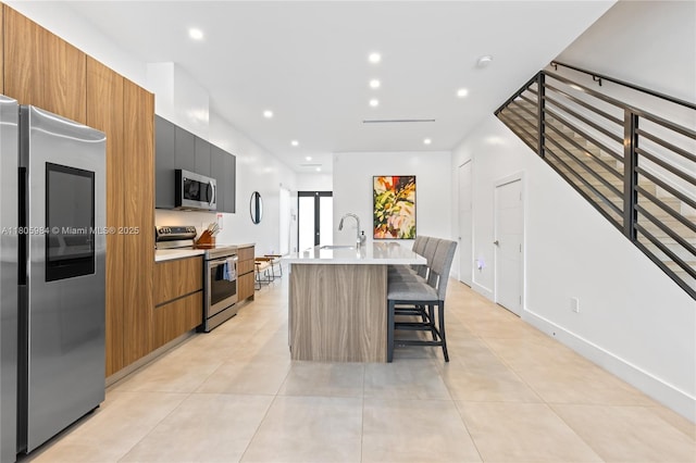 1116 NE 10th Ave, Fort Lauderdale, FL 33304 - kitchen featuring appliances with stainless steel finishes, modern cabinets, a center island with sink, light countertops, and recessed lighting