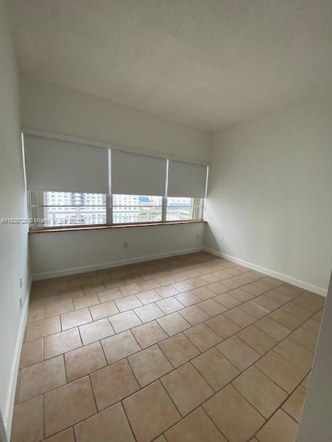 18061 Biscayne Blvd Unit Ph02, Aventura, FL 33160 - tiled spare room featuring baseboards