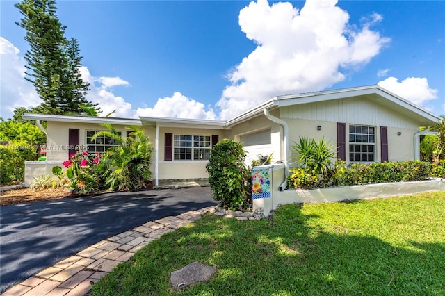 9362 NW 24th Pl, Sunrise, FL 33322 - single story home featuring a garage, asphalt driveway, a front yard, and stucco siding