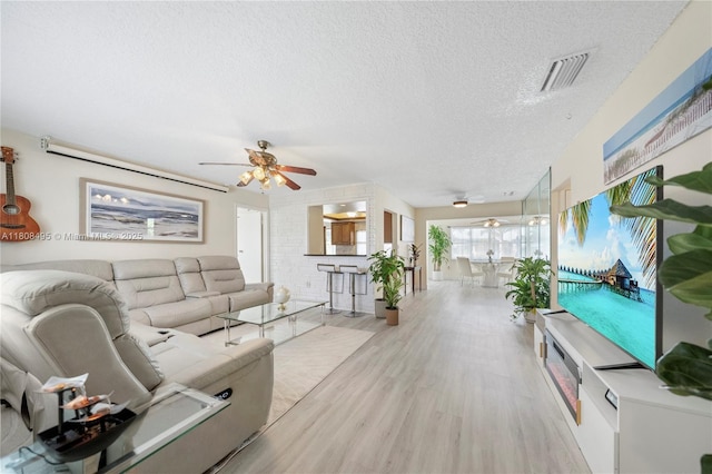 9362 NW 24th Pl, Sunrise, FL 33322 - living area featuring ceiling fan, a textured ceiling, and light wood finished floors