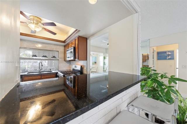 9362 NW 24th Pl, Sunrise, FL 33322 - kitchen with stainless steel appliances, a ceiling fan, a sink, and brown cabinetry