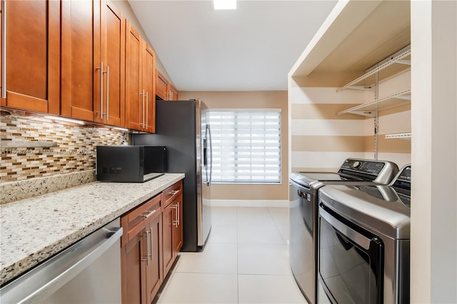 10760 Hickory Ave, Pembroke Pines, FL 33026 - washroom featuring independent washer and dryer, baseboards, and light tile patterned floors