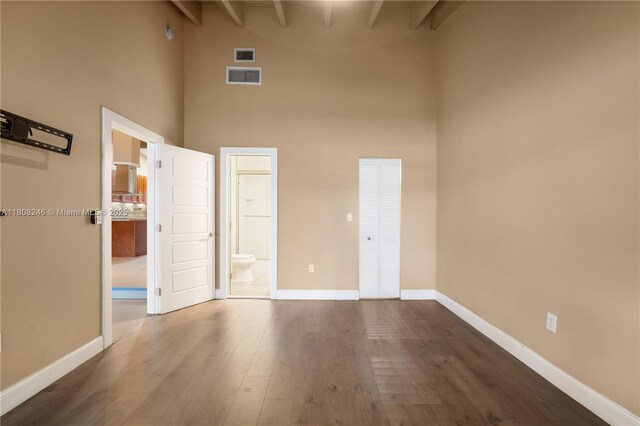 10760 Hickory Ave, Pembroke Pines, FL 33026 - unfurnished bedroom with high vaulted ceiling, dark wood finished floors, ensuite bath, and beamed ceiling