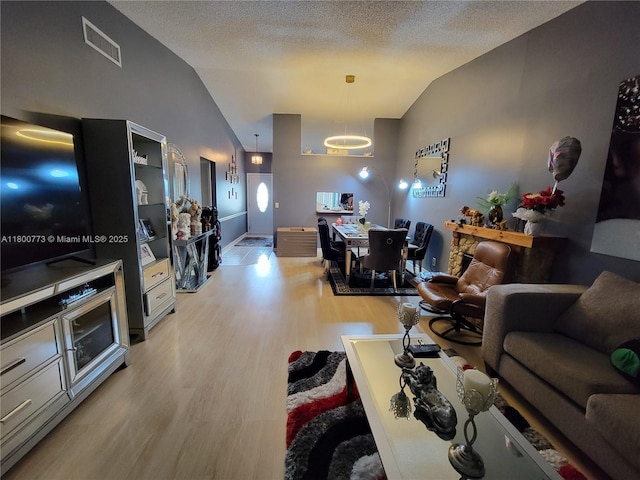 1025 Green Pine Blvd Unit B, West Palm Beach, FL 33409 - living room with vaulted ceiling, light wood finished floors, and a textured ceiling