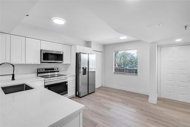 14475 Strathmore Ln Unit 305, Delray Beach, FL 33446 - kitchen featuring stainless steel appliances, white cabinets, light wood-style floors, light stone counters, and recessed lighting