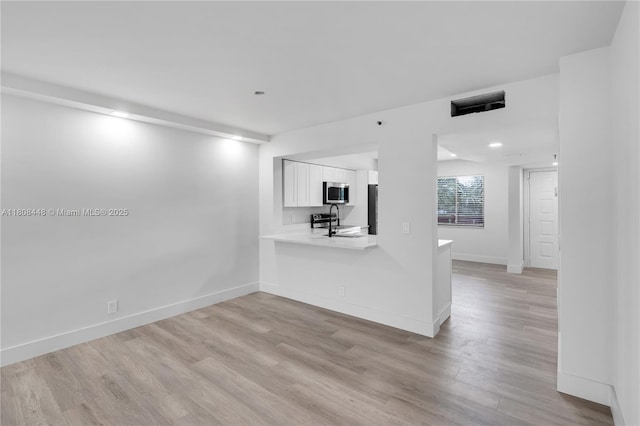 14475 Strathmore Ln Unit 305, Delray Beach, FL 33446 - unfurnished living room with light wood-style flooring, baseboards, and a sink
