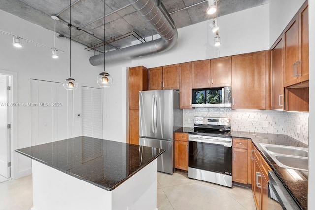 2001 Biscayne Blvd Unit 2308, Miami, FL 33137 - kitchen featuring appliances with stainless steel finishes, a high ceiling, brown cabinetry, and tasteful backsplash