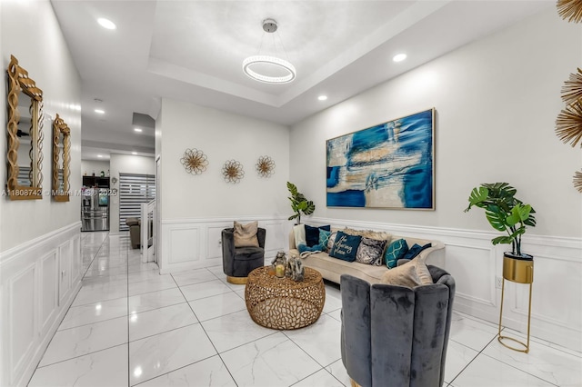 17612 SW 153rd Ave, Miami, FL 33187 - living area featuring a decorative wall, light marble finish floors, wainscoting, recessed lighting, and a raised ceiling