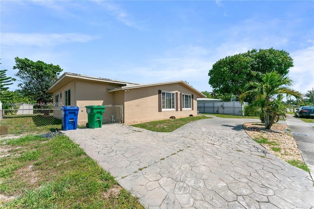 2071 SW 68th Way, Miramar, FL 33023 - view of side of property with decorative driveway, a gate, and stucco siding
