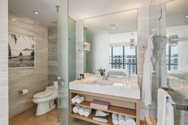 2201 Collins Ave Unit 1511, Miami Beach, FL 33139 - full bathroom featuring vanity, toilet, tile walls, and a shower with shower door
