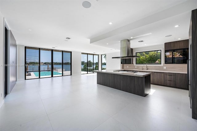 1351 Stillwater Dr, Miami Beach, FL 33141 - kitchen featuring modern cabinets, range hood, light countertops, gas stovetop, and a kitchen island
