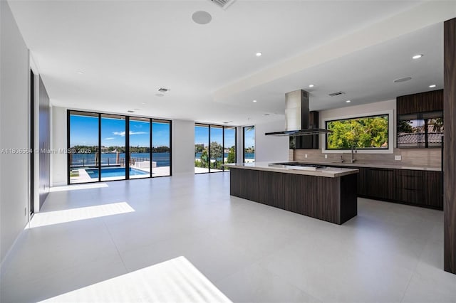 1351 Stillwater Dr, Miami Beach, FL 33141 - kitchen with modern cabinets, island range hood, a center island, dark brown cabinetry, and light countertops