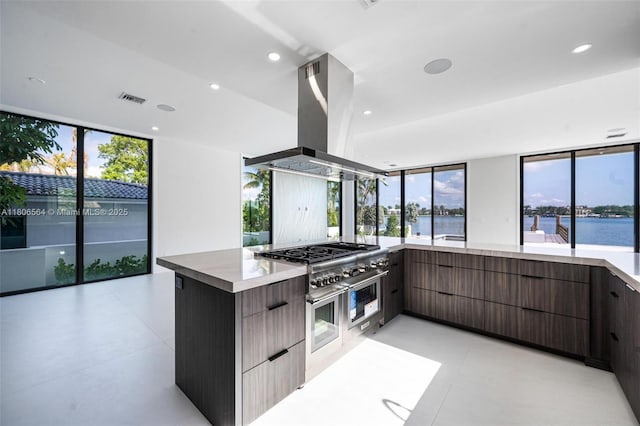 1351 Stillwater Dr, Miami Beach, FL 33141 - kitchen featuring modern cabinets, island exhaust hood, a water view, appliances with stainless steel finishes, and recessed lighting