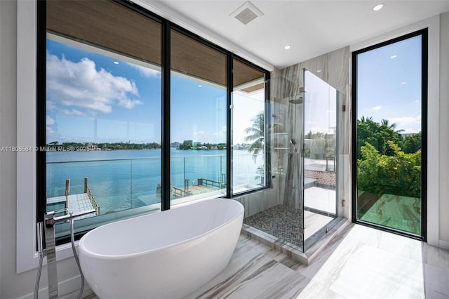 1351 Stillwater Dr, Miami Beach, FL 33141 - bathroom with plenty of natural light, a soaking tub, a water view, marble tiled floors, and recessed lighting