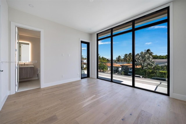 1351 Stillwater Dr, Miami Beach, FL 33141 - empty room featuring light wood finished floors and floor to ceiling windows