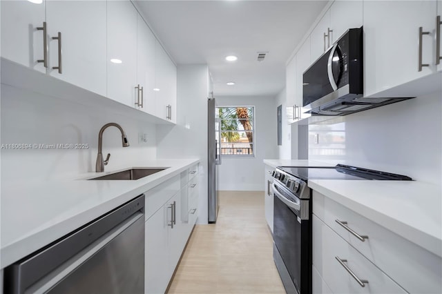 3361 NW 47th Ter Unit 329, Lauderdale Lakes, FL 33319 - kitchen featuring appliances with stainless steel finishes, a sink, light countertops, white cabinetry, and recessed lighting