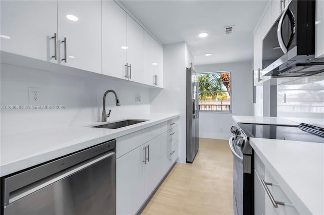 3361 NW 47th Ter Unit 329, Lauderdale Lakes, FL 33319 - kitchen featuring stainless steel appliances, a sink, light countertops, white cabinetry, and recessed lighting