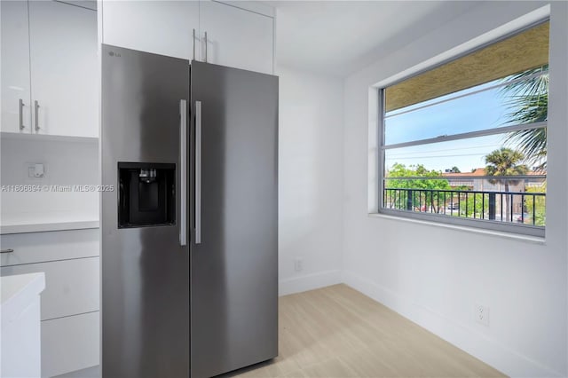 3361 NW 47th Ter Unit 329, Lauderdale Lakes, FL 33319 - kitchen with stainless steel refrigerator with ice dispenser, light countertops, white cabinetry, baseboards, and modern cabinets