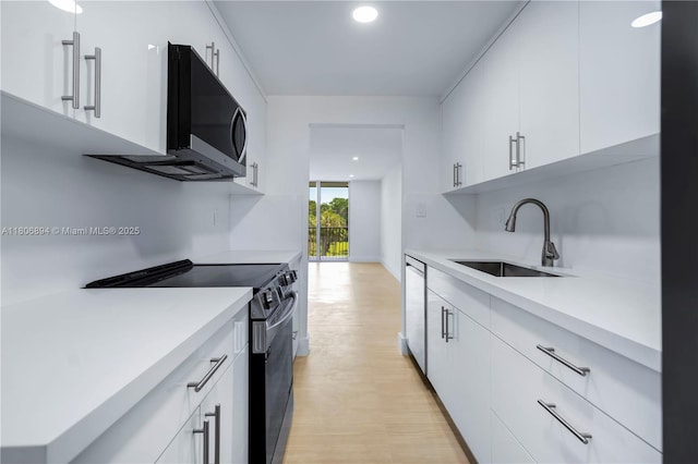 3361 NW 47th Ter Unit 329, Lauderdale Lakes, FL 33319 - kitchen featuring appliances with stainless steel finishes, a sink, light countertops, white cabinetry, and light wood-style flooring