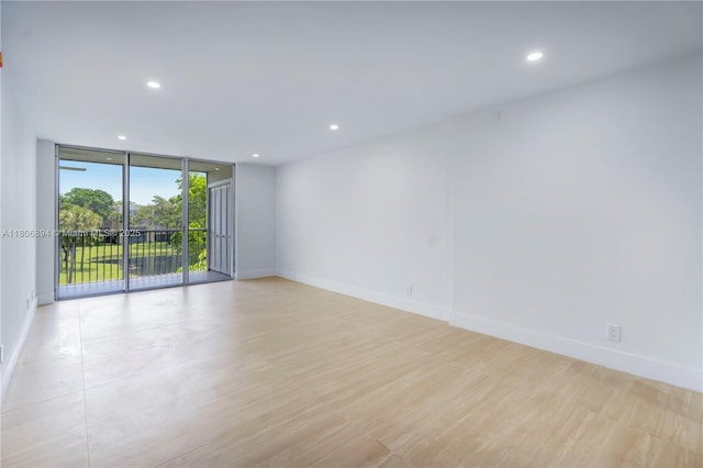 3361 NW 47th Ter Unit 329, Lauderdale Lakes, FL 33319 - spare room with expansive windows, recessed lighting, baseboards, and light wood finished floors