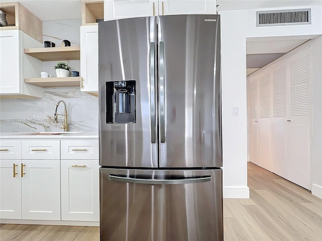 515 Monaco K Unit 515, Delray Beach, FL 33446 - kitchen featuring stainless steel refrigerator with ice dispenser, open shelves, light wood-style floors, and white cabinets
