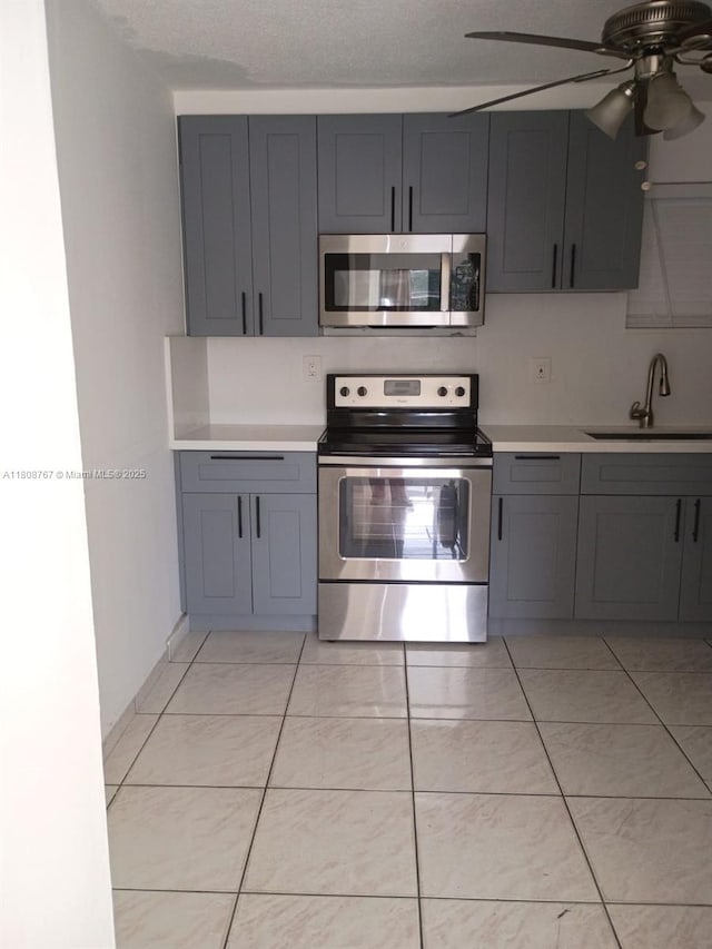 1800 SW 25th St Unit 2305, Miami, FL 33133 - kitchen with stainless steel appliances, gray cabinetry, a sink, and light countertops