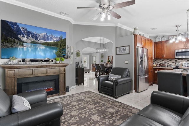 17833 SW 149th Pl, Miami, FL 33187 - living room featuring ceiling fan, arched walkways, light tile patterned floors, ornamental molding, and a glass covered fireplace