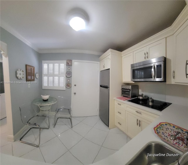 3600 NE 170th St Unit 404, North Miami Beach, FL 33160 - kitchen featuring stainless steel appliances, crown molding, light countertops, light tile patterned floors, and white cabinets