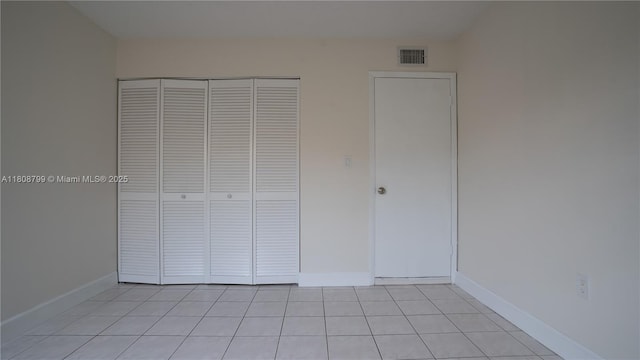 9300 W Flagler St Unit 112D, Miami, FL 33174 - unfurnished bedroom with light tile patterned floors, a closet, and baseboards