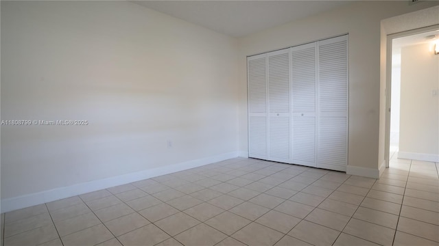 9300 W Flagler St Unit 112D, Miami, FL 33174 - unfurnished bedroom featuring light tile patterned floors, a closet, and baseboards