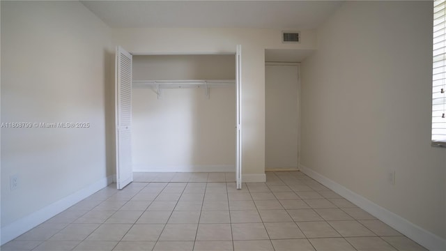 9300 W Flagler St Unit 112D, Miami, FL 33174 - unfurnished bedroom featuring a closet, light tile patterned floors, and baseboards