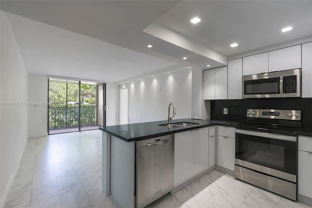 14221 N Kendall Dr Unit 104C, Miami, FL 33186 - kitchen featuring stainless steel appliances, a sink, a peninsula, dark countertops, and light marble finish flooring