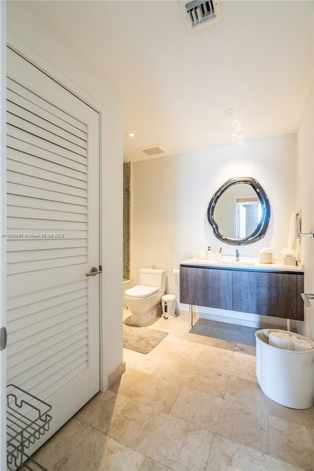 68 SE 6th St Unit 1403, Miami, FL 33131 - bathroom featuring toilet, vanity, and stone finish flooring