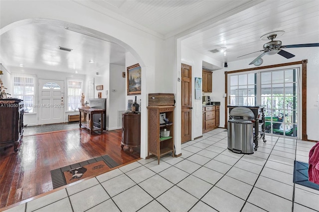 2442 Fillmore St, Hollywood, FL 33020 - living area featuring arched walkways, a ceiling fan, plenty of natural light, light wood-style flooring, and crown molding